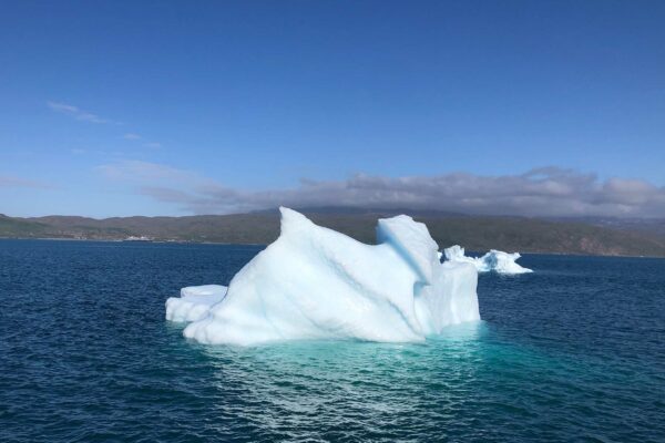 An iceberg floats ominously on the water